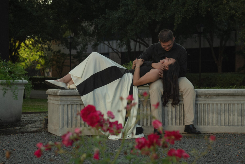 A couple relaxing together on a stone ledge surrounded by flowers