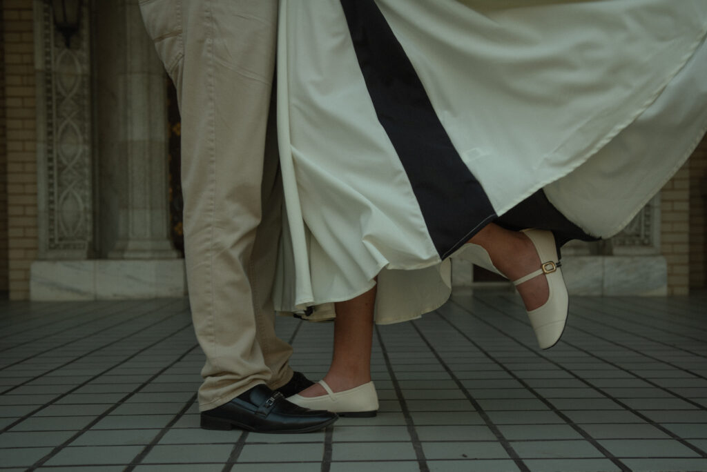 A close-up of a couple standing together as the woman lifts onto her toes.