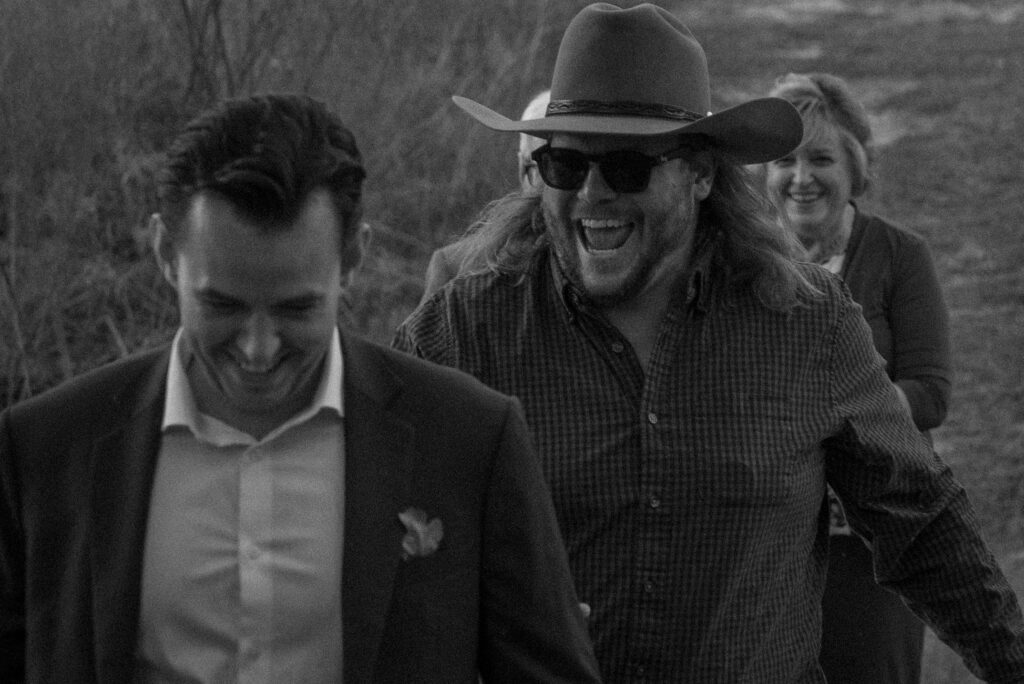 Black and white candid wedding moment of family walking together during a Texas Hill Country elopement.