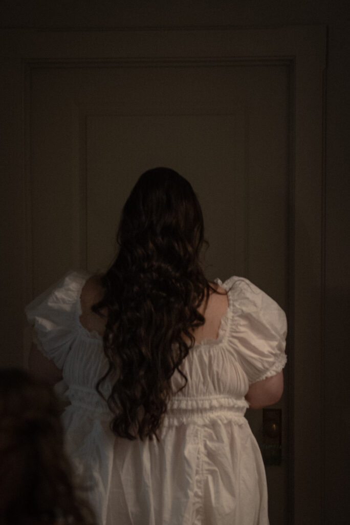 Bride photographed from behind while getting ready in a wedding dress during an intimate Texas Hill Country elopement.