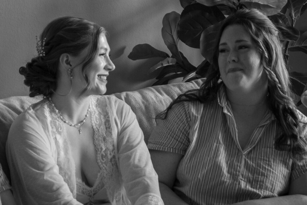 Bride shares an emotional moment with her bridesmaid while getting ready.