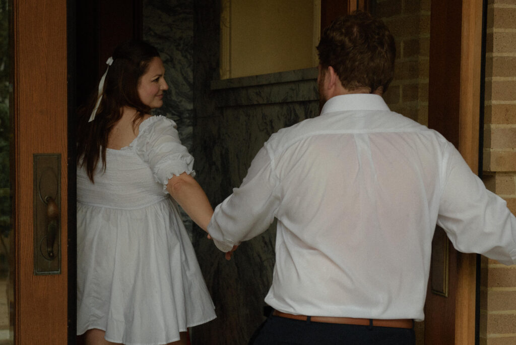Bride and groom holding hands while walking into the historic Houston courthouse during their elopement.