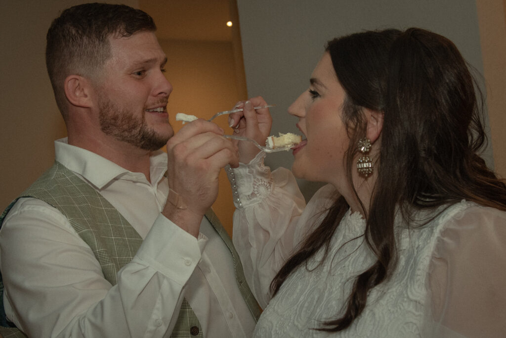 Bride and groom feeding each other cake during an intimate Texas Hill Country elopement