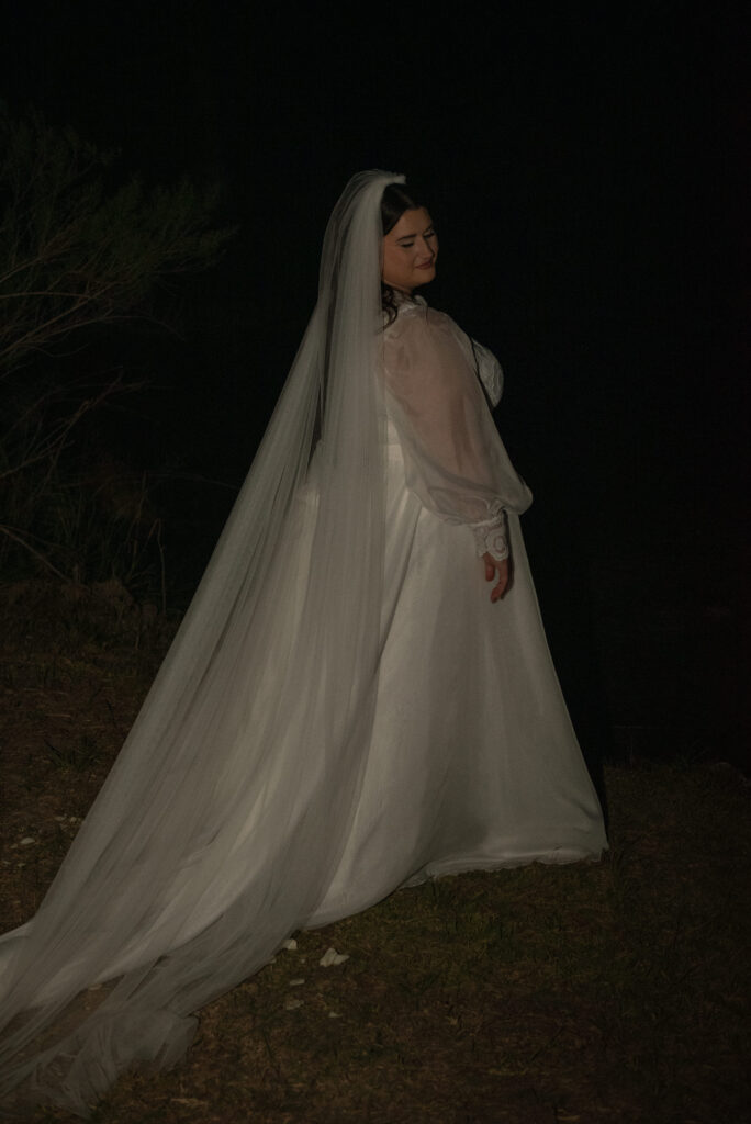 Bride standing alone during moody evening bridal portraits in the Texas Hill Country