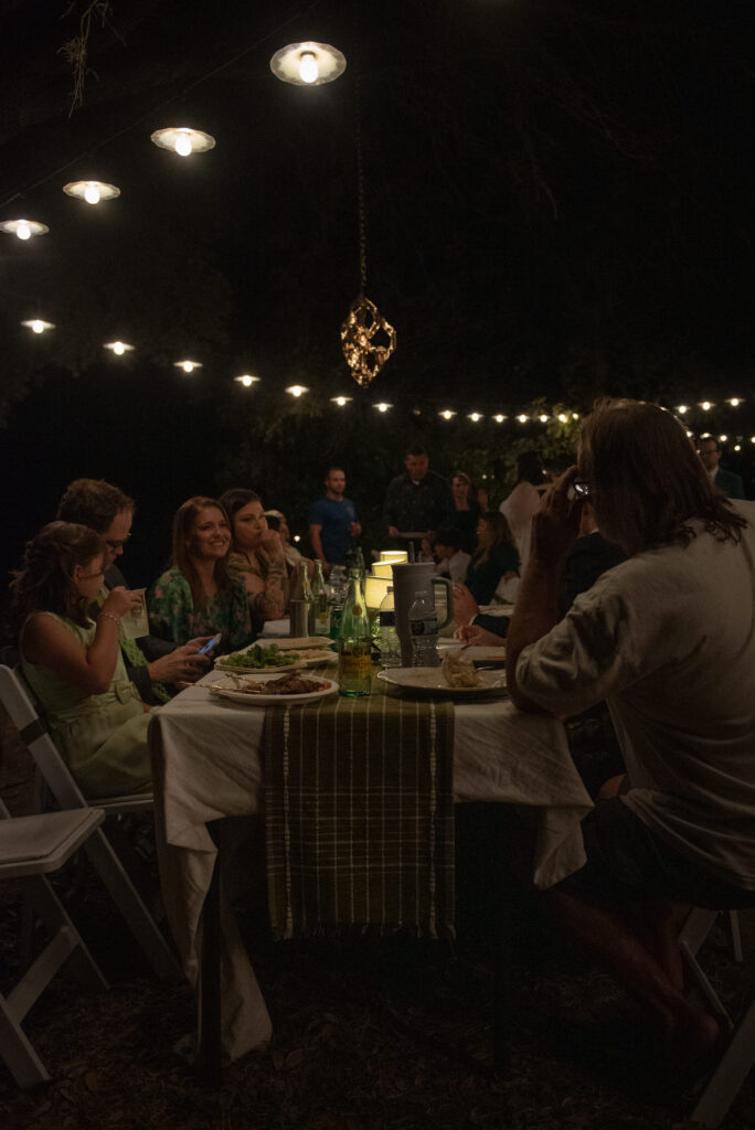 Family gathered around a table under string lights during an intimate Texas Hill Country elopement celebration