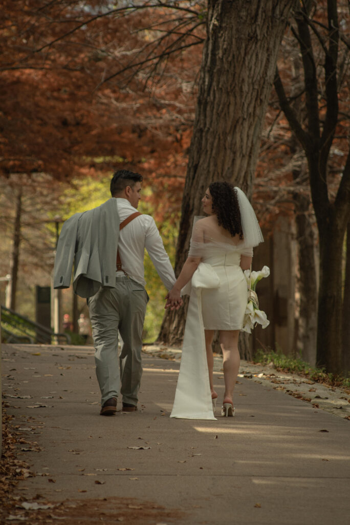 Newlywed couple walking together during Houston elopement portraits near Buffalo Bayou.