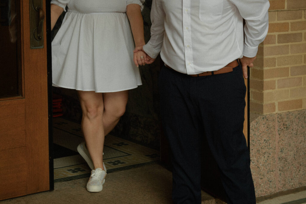 Couple holding hands while stepping out of the courthouse after their Houston elopement ceremony.