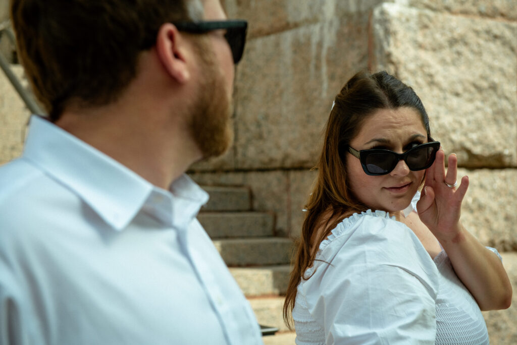 Playful candid moment between a couple wearing sunglasses outside the historic 1910 Courthouse in Houston during their elopement session.