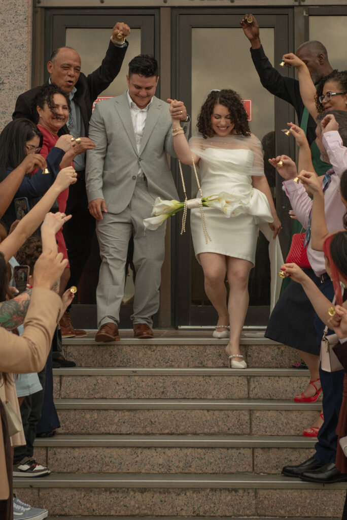 ust married couple walking down courthouse steps during a celebratory courthouse elopement exit in Houston.