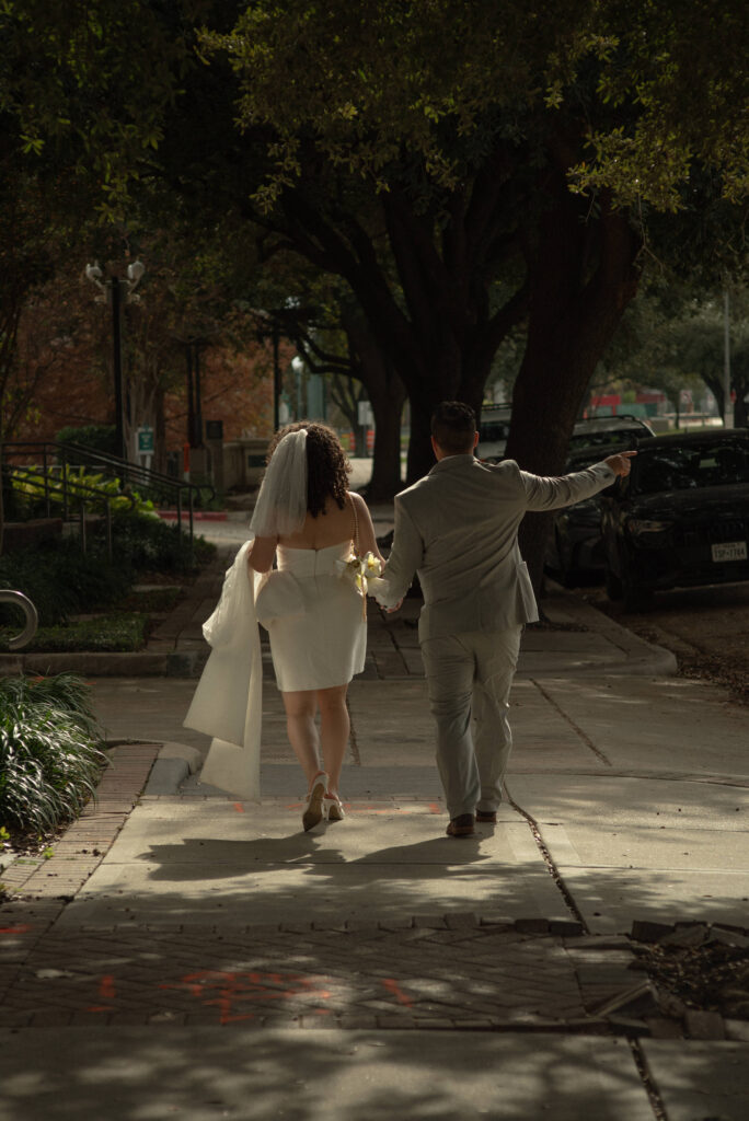 Just married couple walking together in downtown Houston after a courthouse elopement.
