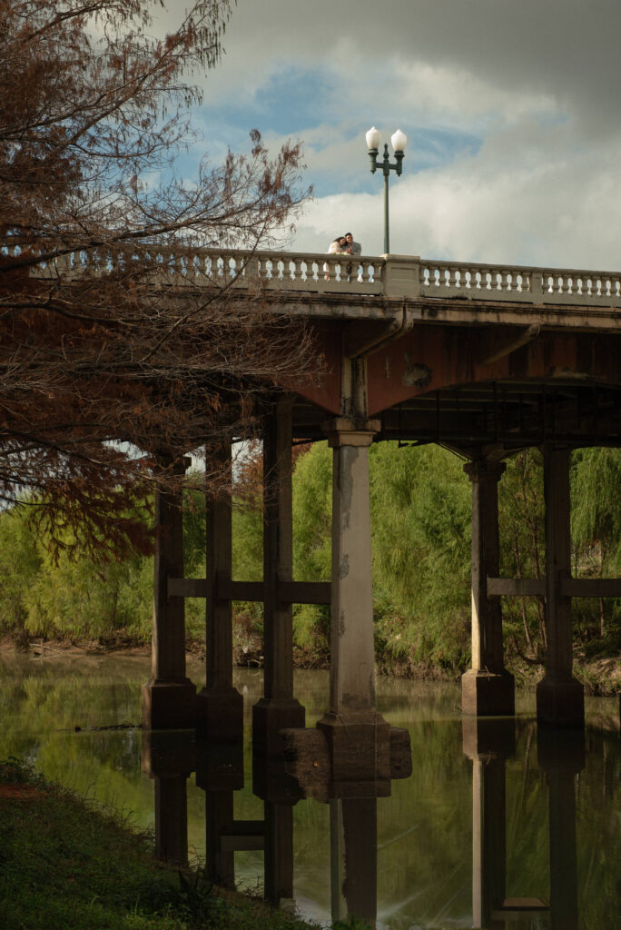 Wide scenic view of a couple on a bridge during Houston elopement portraits near Buffalo Bayou.