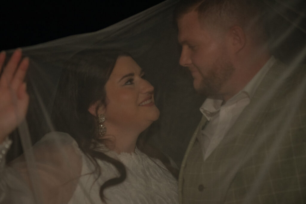 Bride and groom sharing a quiet moment beneath a veil during Hill Country elopement portraits