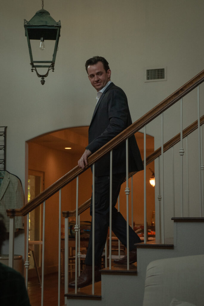 Candid groom portrait on stairs during an intimate wedding celebration in the Texas Hill Country.
