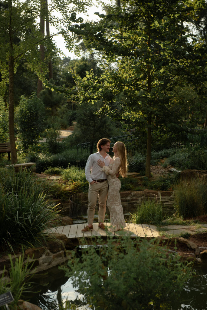 Couple standing together on a garden bridge during an engagement session at Mercer Botanic Gardens in Houston Texas