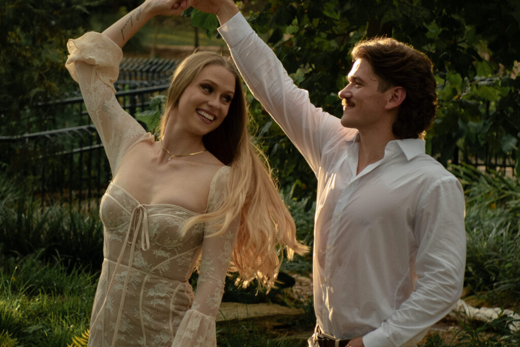 Candid golden hour engagement photo of a couple dancing together at Mercer Botanic Gardens in Houston Texas