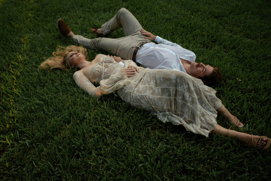 Artistic engagement photo of a couple laying together in the grass at Mercer Botanic Gardens in Houston Texas