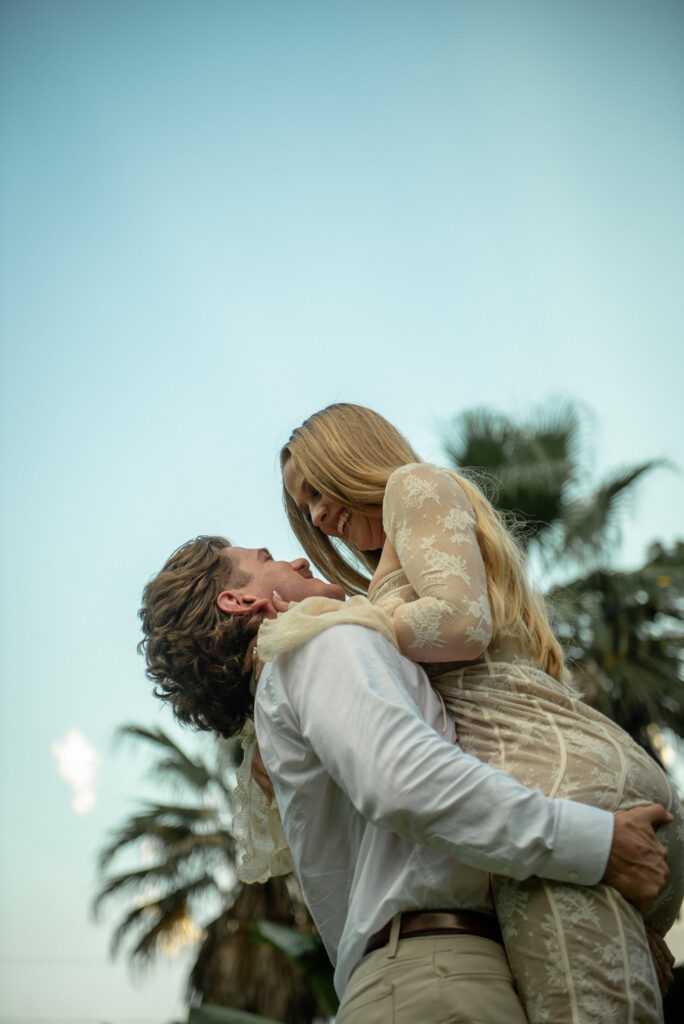 Joyful engagement photo of a couple sharing a lifted embrace at Mercer Botanic Gardens in Houston Texas
