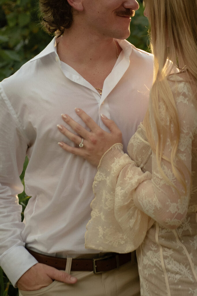 Close up of an engagement ring on a woman's hand during a romantic outdoor engagement session with natural light