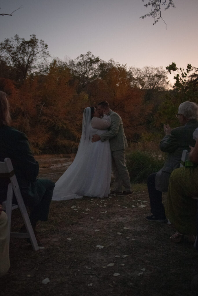 Couple sharing their first kiss after an outdoor elopement ceremony in Texas