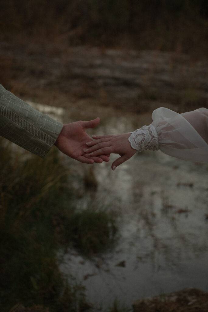 Close up of hands reaching during an intimate outdoor elopement ceremony in Texas