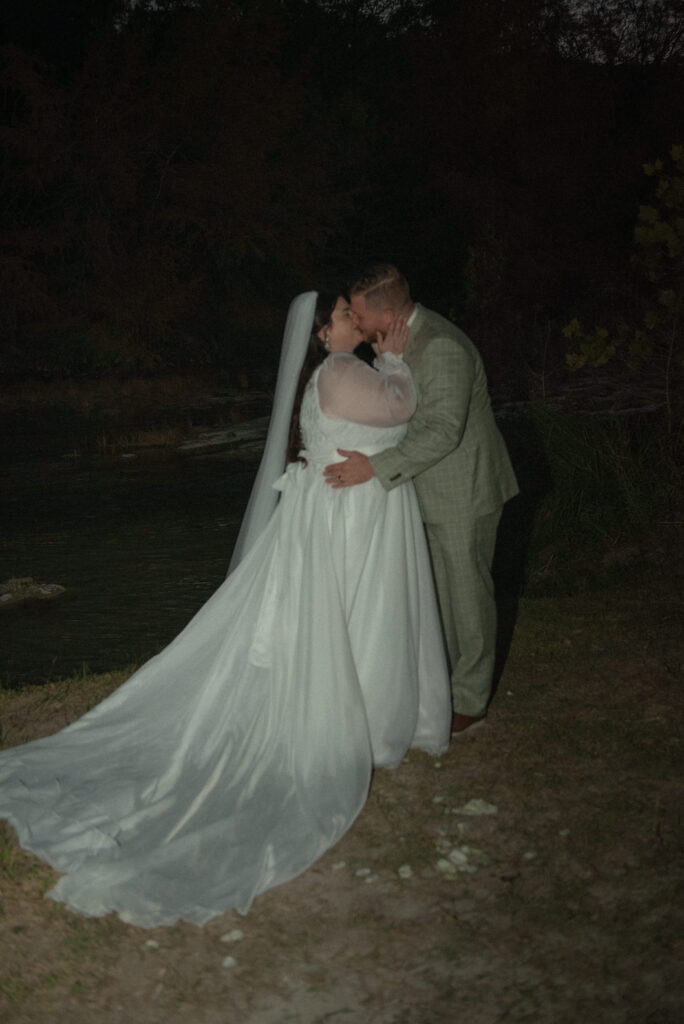 Bride and groom sharing an intimate kiss during nighttime elopement portraits in the Texas Hill Country