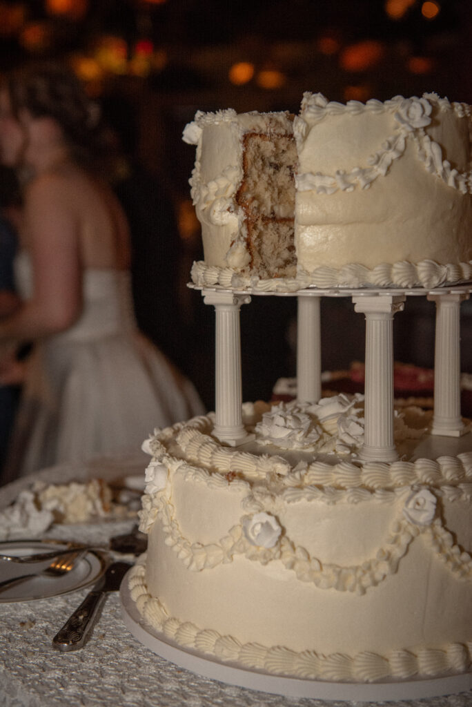 Close-up of the couple’s tiered vintage-style wedding cake after being sliced