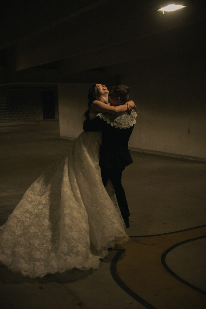 Couple practicing their first dance in a softly lit garage.