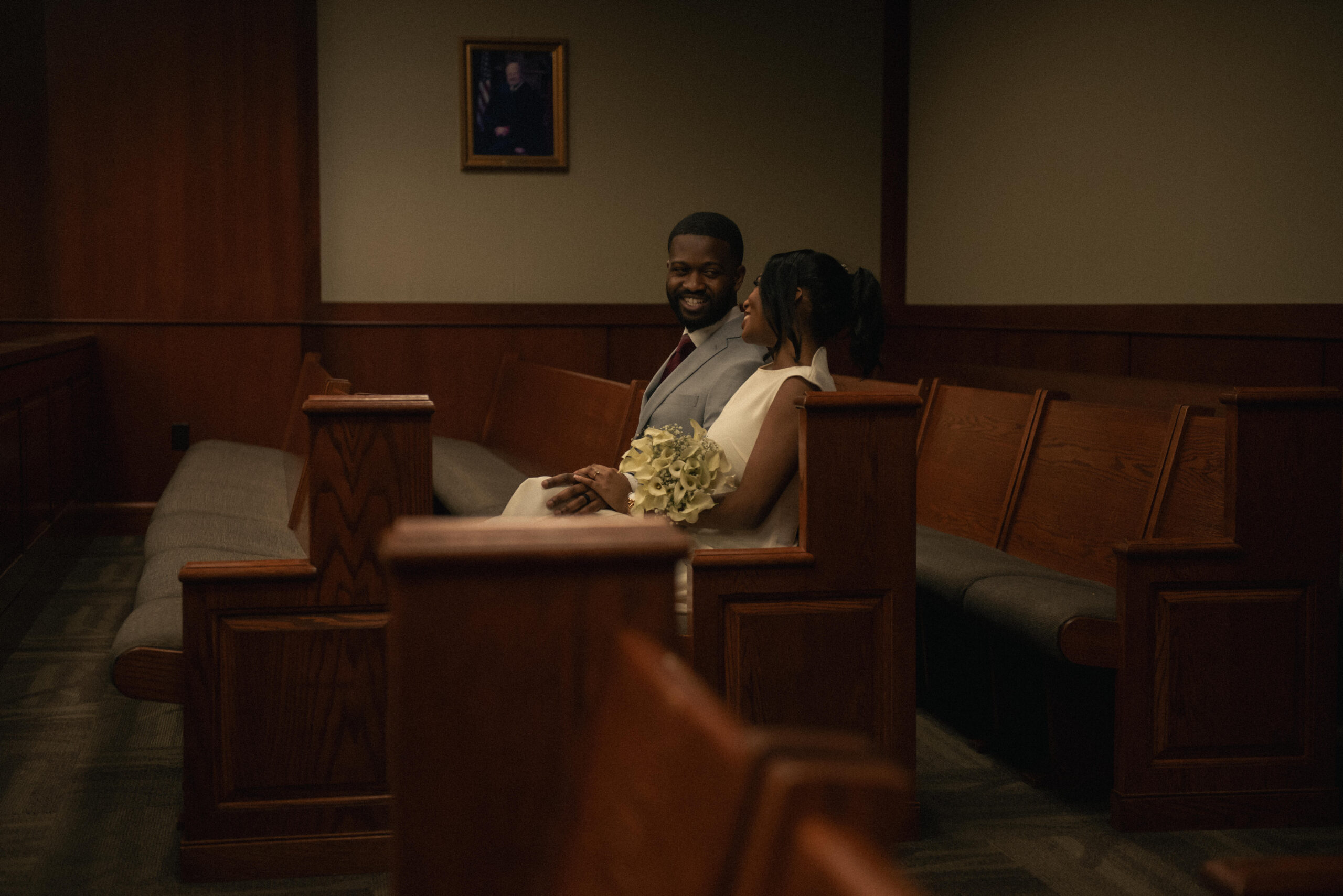 Couple seated together after a courthouse ceremony in a calm documentary frame.