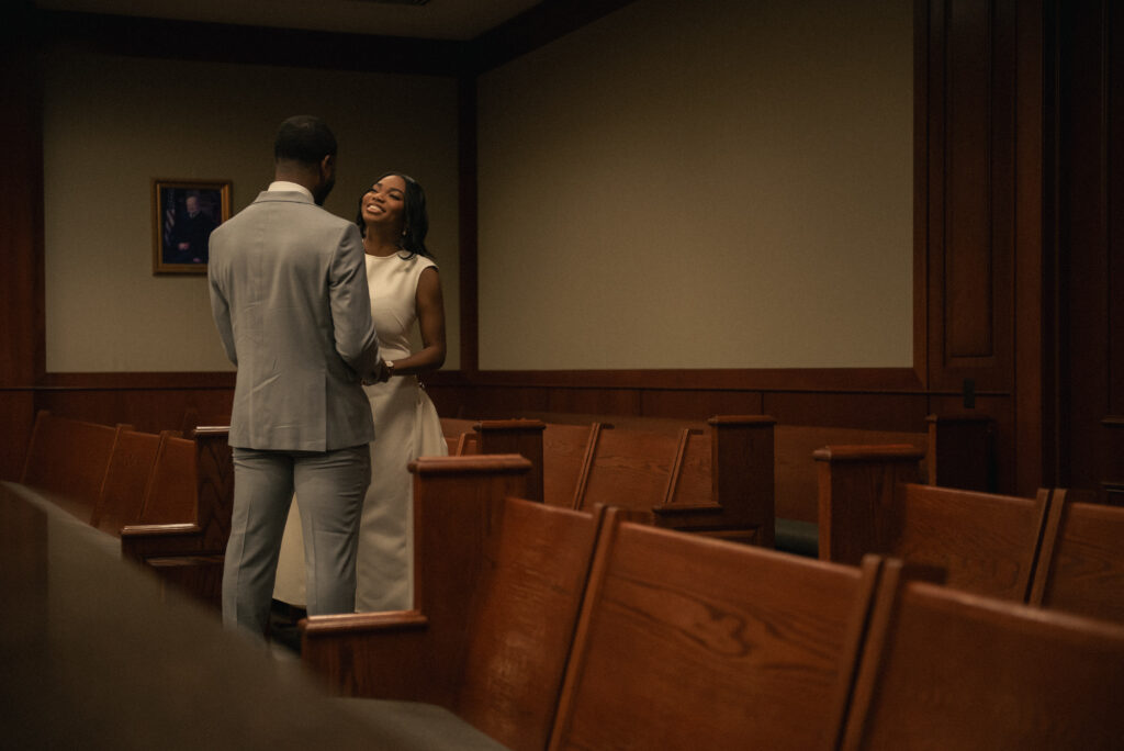 Candid courthouse wedding moment with the couple smiling and talking quietly.