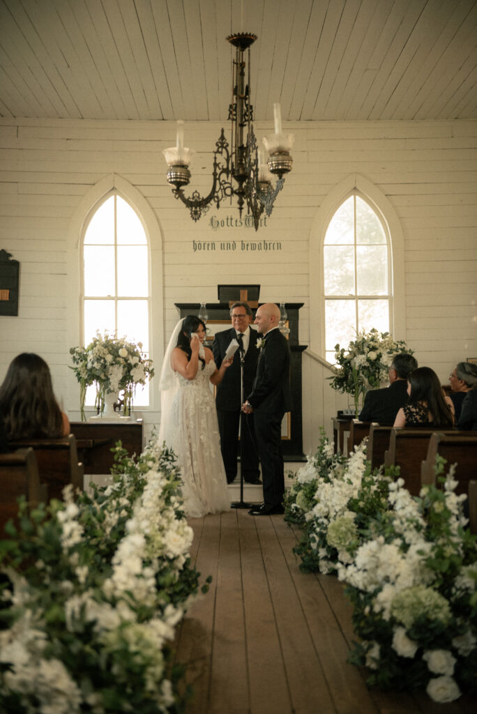 Couple exchanging vows during an intimate chapel wedding ceremony.