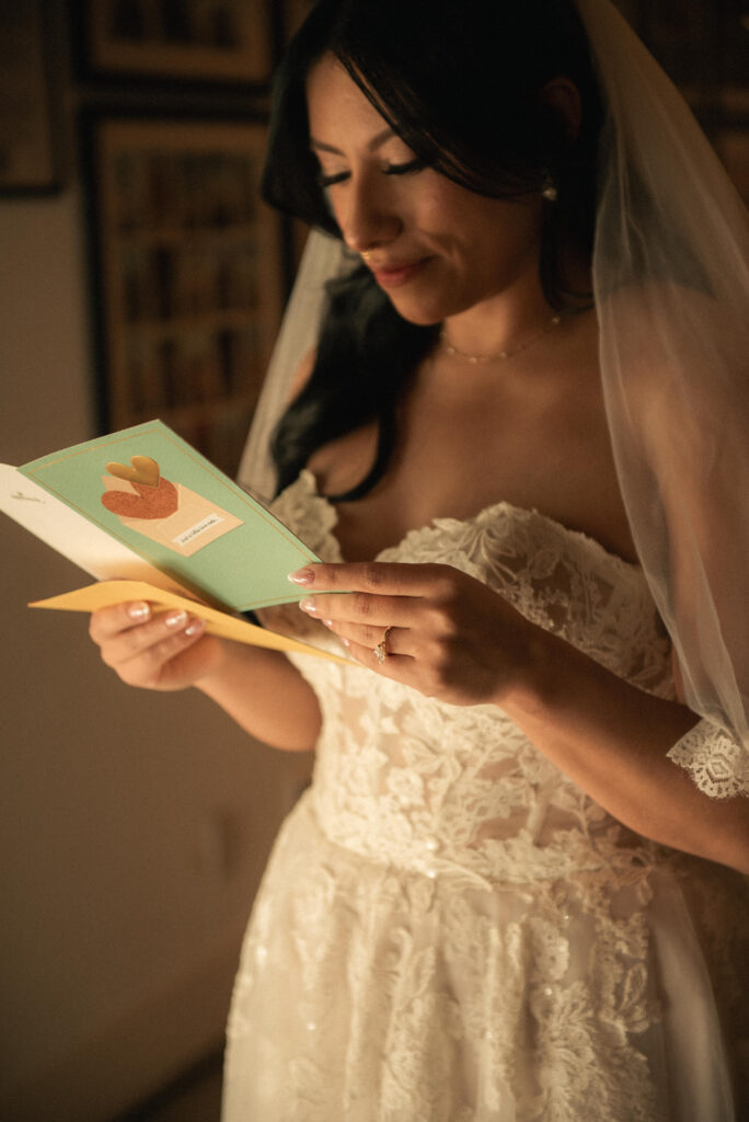 Bride reading a note during getting ready, captured in warm natural light.