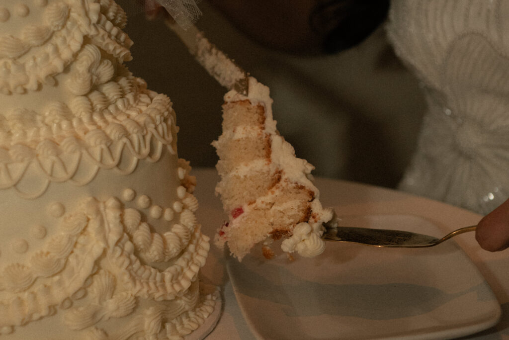 Close-up of cake slice being served during the wedding reception.