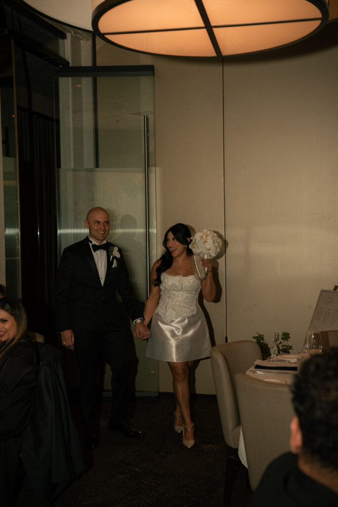 Couple entering the reception hand in hand in a documentary-style photo.