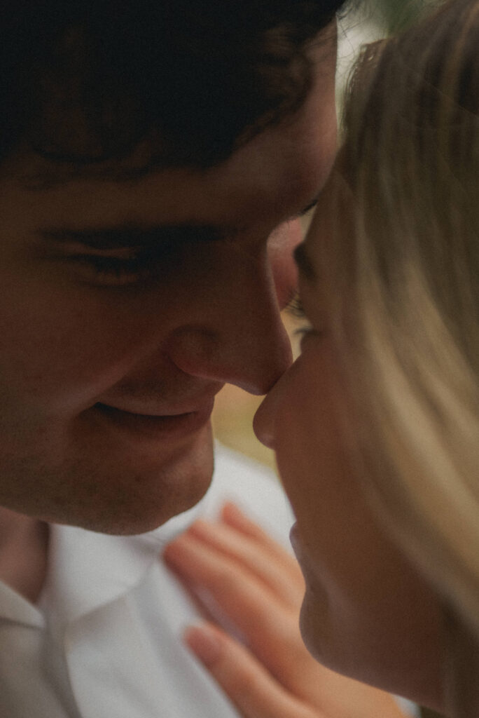 Candid close-up of an engaged couple holding each other during Houston park photos.