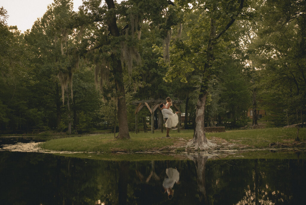 Engaged couple lift during golden hour in a Houston park engagement session.