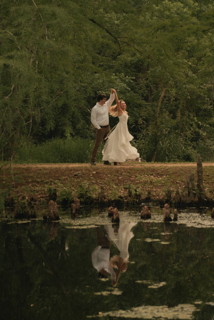 Engaged couple dancing together on a trail during a Houston park engagement session.